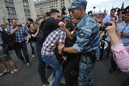 Несанкионированная акция в поддержку блогера, основателя антикоррупционного проекта `РосПил` Алексея Навального, обвиняемого в растрате имущества `Кировлеса` и приговоренного Ленинским судом г.Кирова к пяти годам лишения свободы. Митинг прошел на Манежной площади. На снимке: потасовка между активистом и полицейским на Тверской улице.