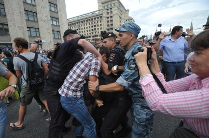 Несанкионированная акция в поддержку блогера, основателя антикоррупционного проекта `РосПил` Алексея Навального, обвиняемого в растрате имущества `Кировлеса` и приговоренного Ленинским судом г.Кирова к пяти годам лишения свободы. Митинг прошел на Манежной площади. На снимке: потасовка между активистом и полицейским на Тверской улице.