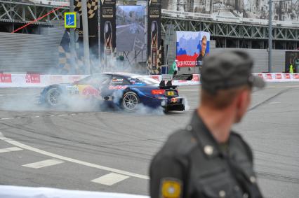 Автошоу Moscow City Racing. День второй. На снимке: гоночный автоомбиль и полицейский