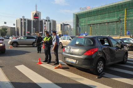 ДТП. На снимке: аварийный автомобиль и сотрудники ДПС на пешеходном переходе.