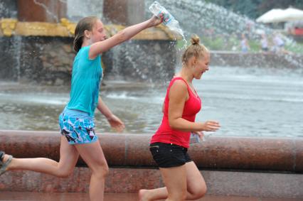 Водная битва на ВВЦ 2013. На снимке:  девушки обливают друг друга водой.