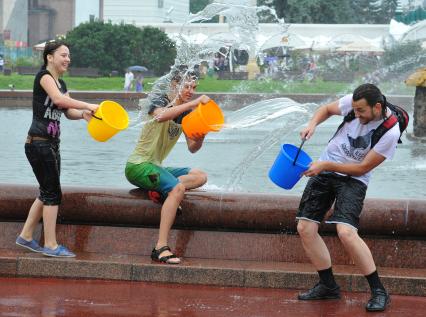 Водная битва на ВВЦ 2013. На снимке: молодые люди обливают друг друга водой.