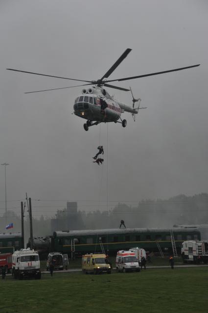 5-й международный салон `Комплексная безопасность-2013`. Полигон 179-го спасательного центра МЧС. Демонстрационно-полевые учения по ликвидации последствий `землетрясения`. На снимке: спасатель со служебной собакой десантируются с вертолета.