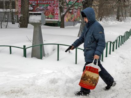 Подросток идет с пистолетом по улице.