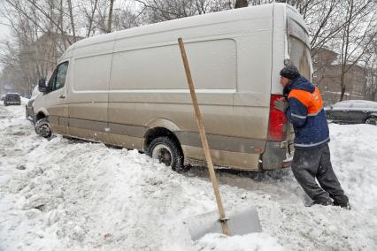 Снегопад в Москве. На снимке: дворник помогает водителю выехать из сугроба.