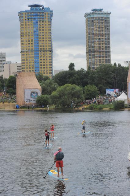 Фестиваль самодельных летательных аппаратов Red Bull Flugtag в Строгино. На снимке: спортсмены плывут на досках. На втором плане: высотные дома ЖК `Янтарный город`.