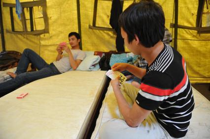 2-ой Иртышский проезд. Палаточный лагерь для временного содержания нелегальных мигрантов, ожидающих депортации на родину. На снимке: мигранты играют в карты.