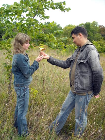 Молодой человек дарит девушке гриб.