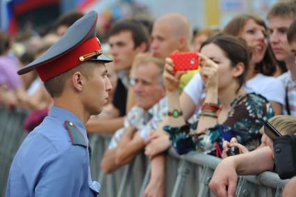 Красная площадь. Старт российского этапа международного ралли-марафона `Шелковый путь-2013`. На снимке: сотрудник правохранительных органов и зрители.