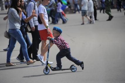 ЦПКиО им. Горького. День воздушно-десантных войск (ВДВ). На снимке: мальчмк в голубом беоете едет на самокате.