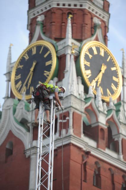 Монтаж металлической конструкции на Красной площади . На снимке: промышленный альпенист на фона Спасской башни Кремля.