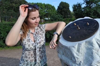 ПКиО `Сокольники`.   На снимке: часы на руке девушки и солнечные часы .