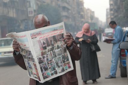 Каир. На снимке: египтянин читает газету.
