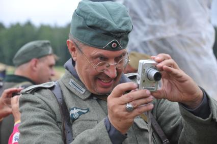 Военно-историческая реконструкция событий Второй мировой. На снимке: участник военной реконструкции,  солдат в немецкой военной форме времен ВОВ с фотоаппаратом.