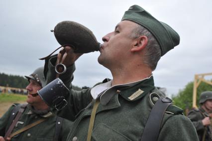 Военно-историческая реконструкция событий Второй мировой. На снимке: участник военной реконструкции,  солдат в немецкой военной форме времен ВОВ пьет из фляги