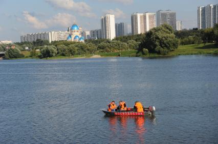 Борисовские пруды. На снимке: мужчины в лодке с надписью `Мосводосток`