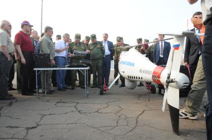 Учебно-тренировочный комплекс общевойскового полигона `Алабино`. Демонстрация комплексов беспилотных летательных аппаратов (БПЛА). На снимке: министр обороны РФ Сергей Шойгу (в центре) и начальник Генерального штаба ВС РФ, генерал армии Валерий Герасимов (пятый справа). БПЛА Camcopter S 100 австрийской фирмы Schiebel (справа).