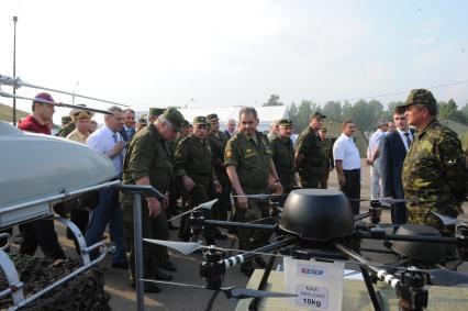 Учебно-тренировочный комплекс общевойскового полигона `Алабино`. Демонстрация комплексов беспилотных летательных аппаратов (БПЛА). На снимке: министр обороны РФ Сергей Шойгу (в центре). БПЛА `НЕЛК`-В12 (справа).
.