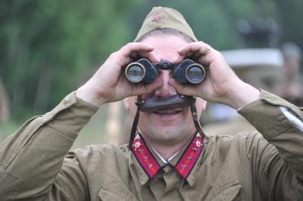 Военно-историческая реконструкция событий Второй мировой. На снимке: солдат смотрит в бинокль.