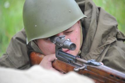 Военно-историческая реконструкция событий Второй мировой. На снимке: солдат смотрит в прицел