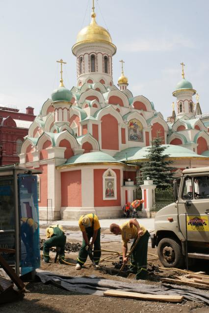 Церковь Казанской иконы Божией Матери. Рабочие укладывают тротуарную плитку.