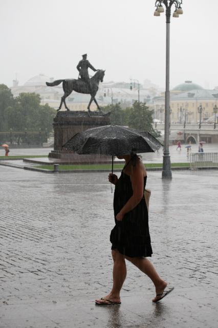 Дождь в городе. На снимке: девушка под зонтом