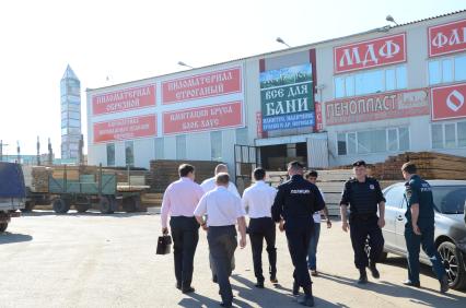 42-ой километр Калужского шоссе. Cотрудники Управления охраны общественного порядка (УООП) провели рейд `Нелегальный мигрант`. В ходе проверки ТК `Славянский мир` обнаружен поселок нелегальных мигрантов. На снимке: сотрудники полиции и УООП.
