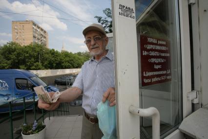 Большая Дорогомиловская, д 6. Бюджетный магазин. На снимке: пенсионр держит в руках деньги.