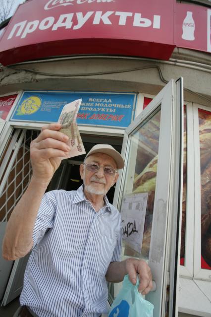 Большая Дорогомиловская, д 6. Бюджетный магазин. На снимке: пенсионр держит в руках сторублевую купюру.