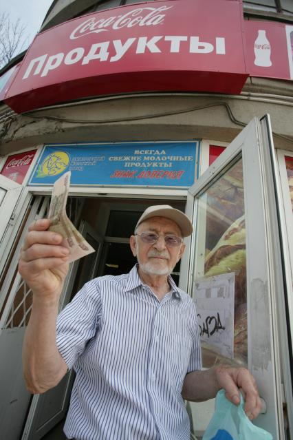 Большая Дорогомиловская, д 6. Бюджетный магазин. На снимке: пенсионр держит в руках сторублевую купюру.