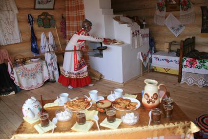 Русские традиции. На снимке: женщина с кочергой у русской печи