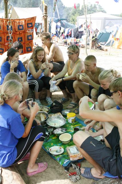 Отдых в лагере. На снимке: молодые люди во время приема пищи.