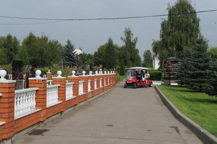 На Митинском кладбище начал курсировать бесплатный электромобиль. На снимке: люди едут на электромобиле.