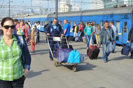 Киевский вокзал. На снимке: носильщик везет багаж на грузовой тележке.