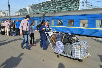 Киевский вокзал. На снимке: носильщик везет багаж на грузовой тележке.