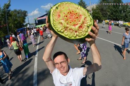 Мужчина держит в руках резной арбуз