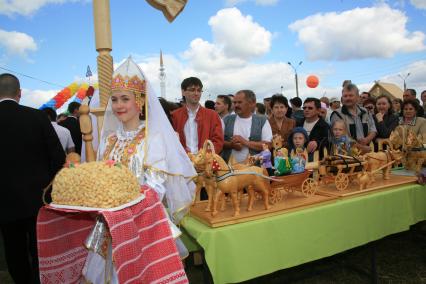 Праздник Сабантуй. Торговля сувенирной продукцией. На снимке: девушка держит поднос с восточными сладостями.