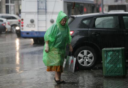 Дождь в городе. На снимке: женщина в дождевике.