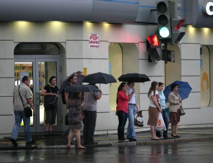 Дождь в городе. На снимке: люди с зонтами