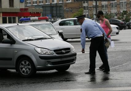 Сотрудник ГИБДД осматривает автомобиль без номерного знака.