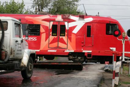 Железнодорожный переезд. На снимке: электропоезд  `Аэроэкспресс` и автомобиль