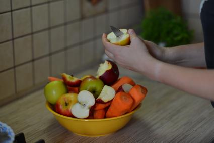 Девушка режет яблоко.