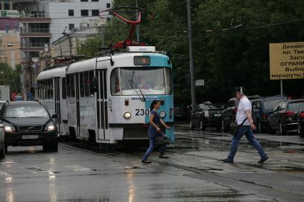 Трамвай и автомобили на городском шоссе.