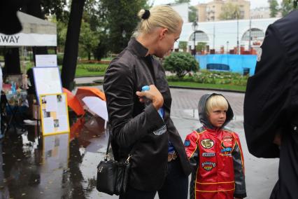 В московском саду `Эрмитаж` прошел веселый праздник для детей и взрослых `Здравствуй, школа, новый год!`, организованный телеведущей Татьяной Лазаревой. На снимке: супруга кандидата на выборах мэра Москвы 2013, блогера Алексея Навального Юлия Навальная с сыномсыном Захаром.