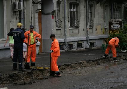 Дорожно-ремонтные работы. На снимке: рабочие копают траншею.