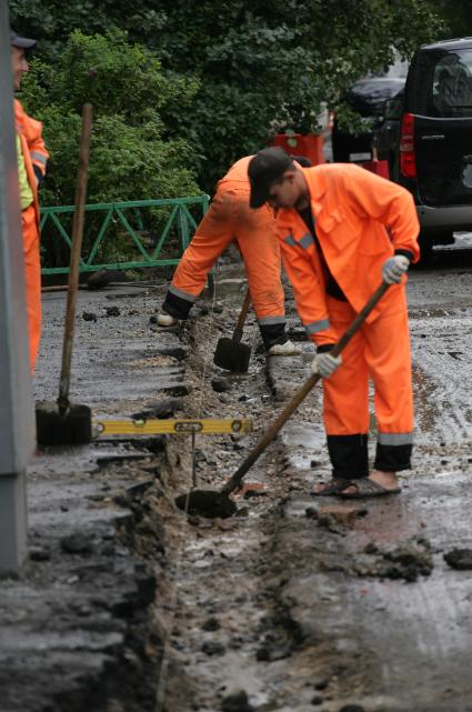 Дорожно-ремонтные работы. На снимке: рабочие копают траншею.