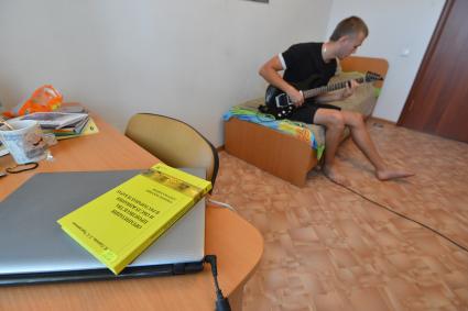 Общежитие № 8 в Оренбурге. На снимке: студент в комнате играет на электронной гитаре.