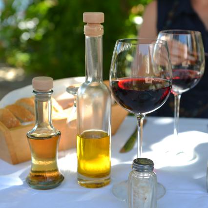 Греция. На снимке: оливковое масло и бокалы красного вина.