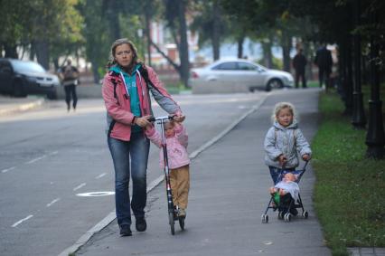 Мама с детьми гуляют в Петровском парке.