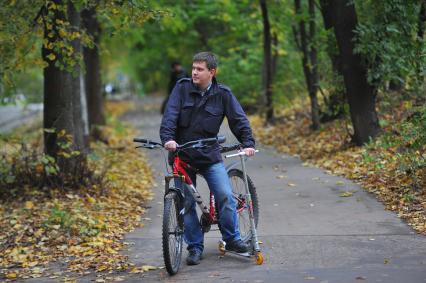 День отказа от автомобиля. На снимке: мужчина с велосипедом и самокатом.